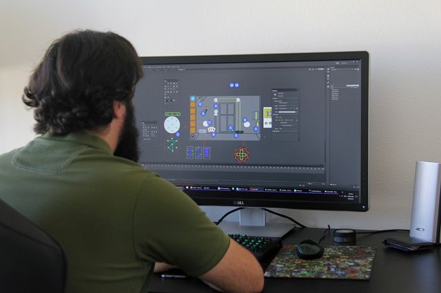 Разработчик инди игры работает за ноутбуком дома